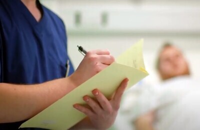 Врач в больничной палате делает запись